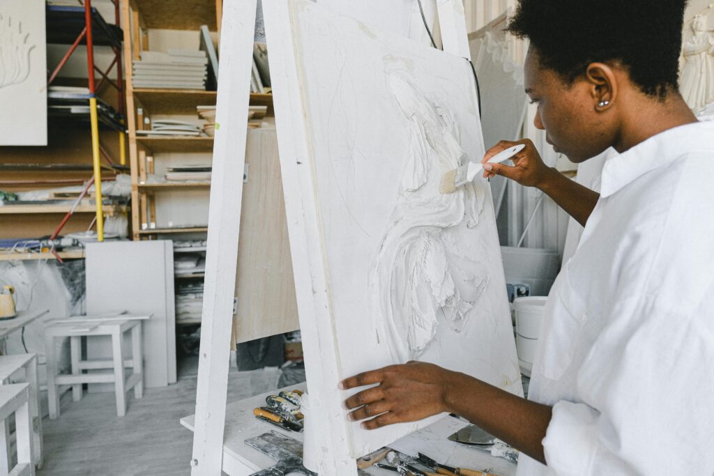 Artist focused on painting in a creative workshop space, capturing the essence of creativity.